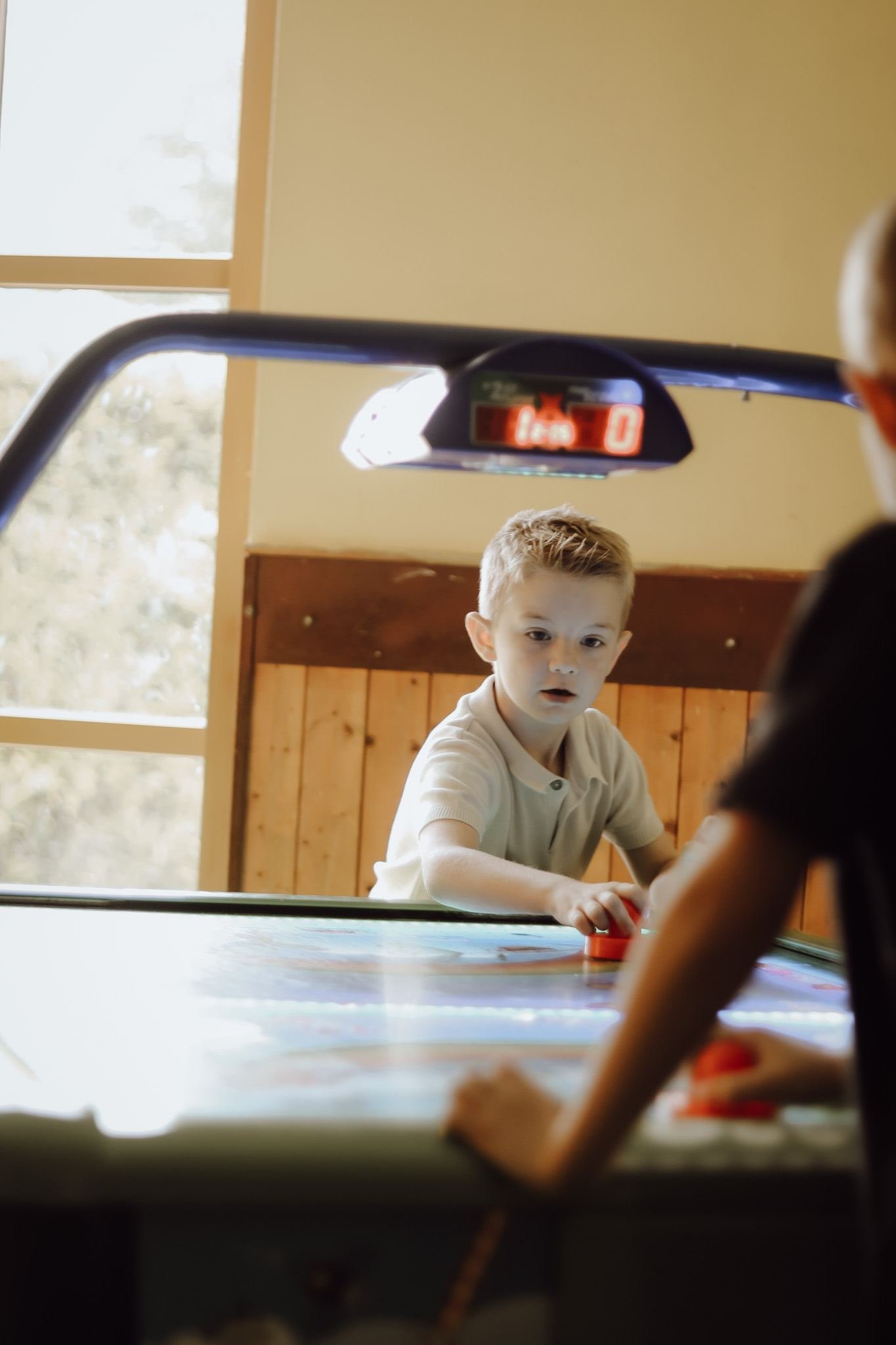 Kind speelt airhockey in de indoor speelruimte Los Bandidos del Rodeo