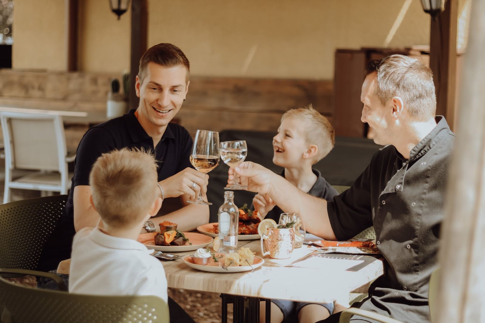 Familie proost samen aan tafel op het terras